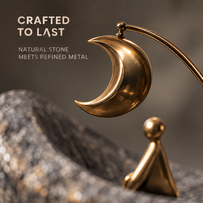Textured gray boat sculpture with seated gold-tone figure and hanging crescent moon, without text